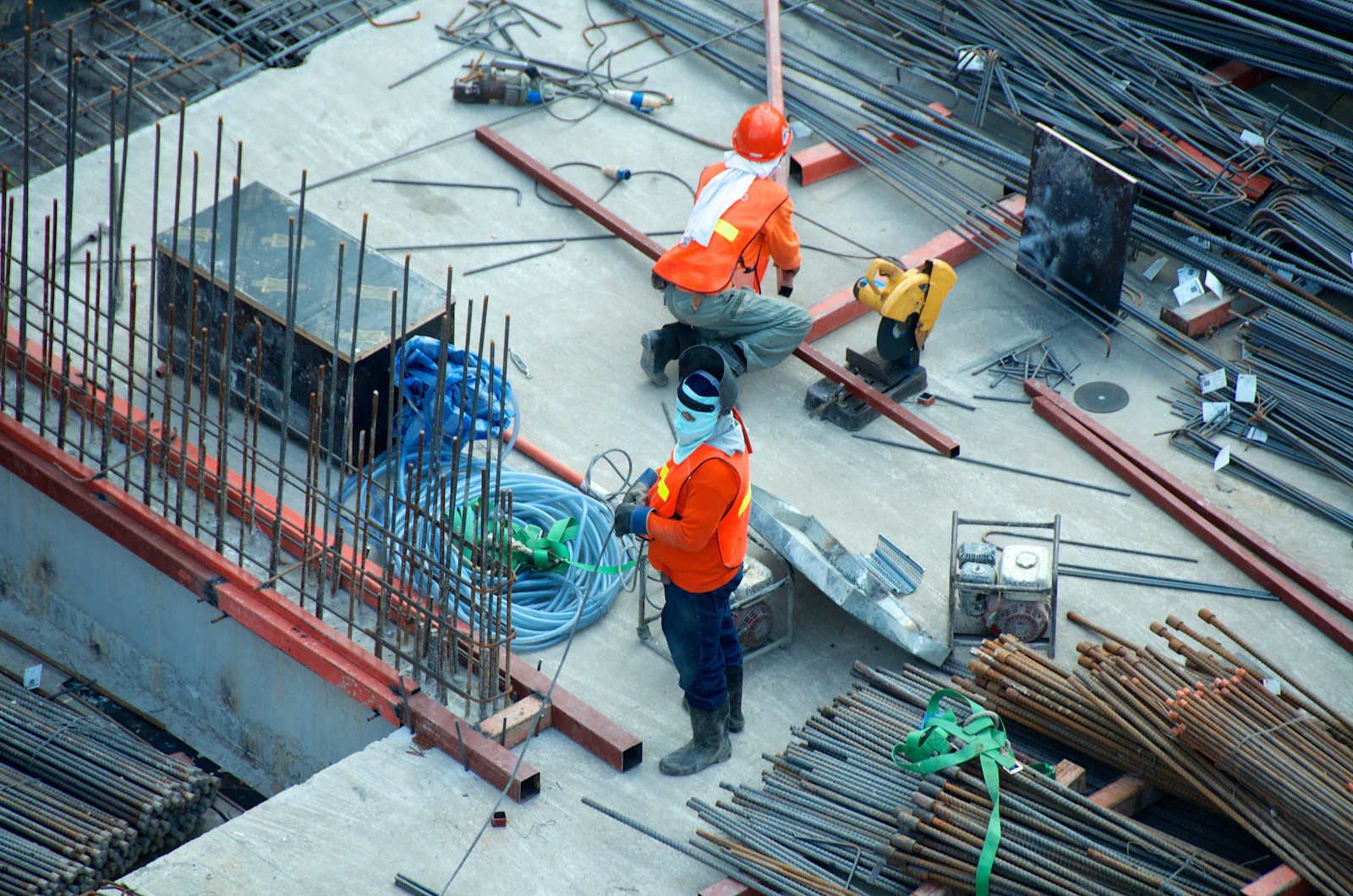 Construction workers on a Dubai site standing among steel reinforcement bars before a concrete pour