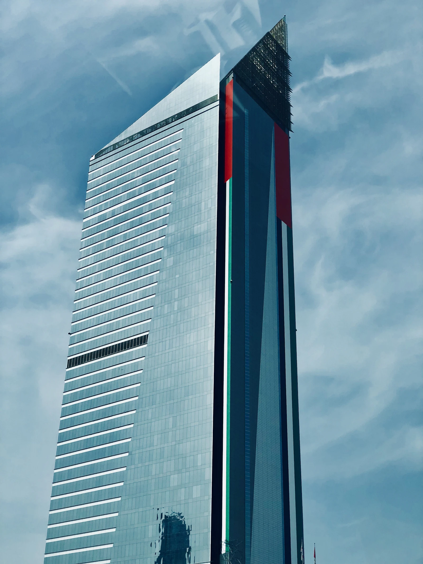 Modern glass office tower near Dubai Internet City against a clear blue sky, home to technology company offices