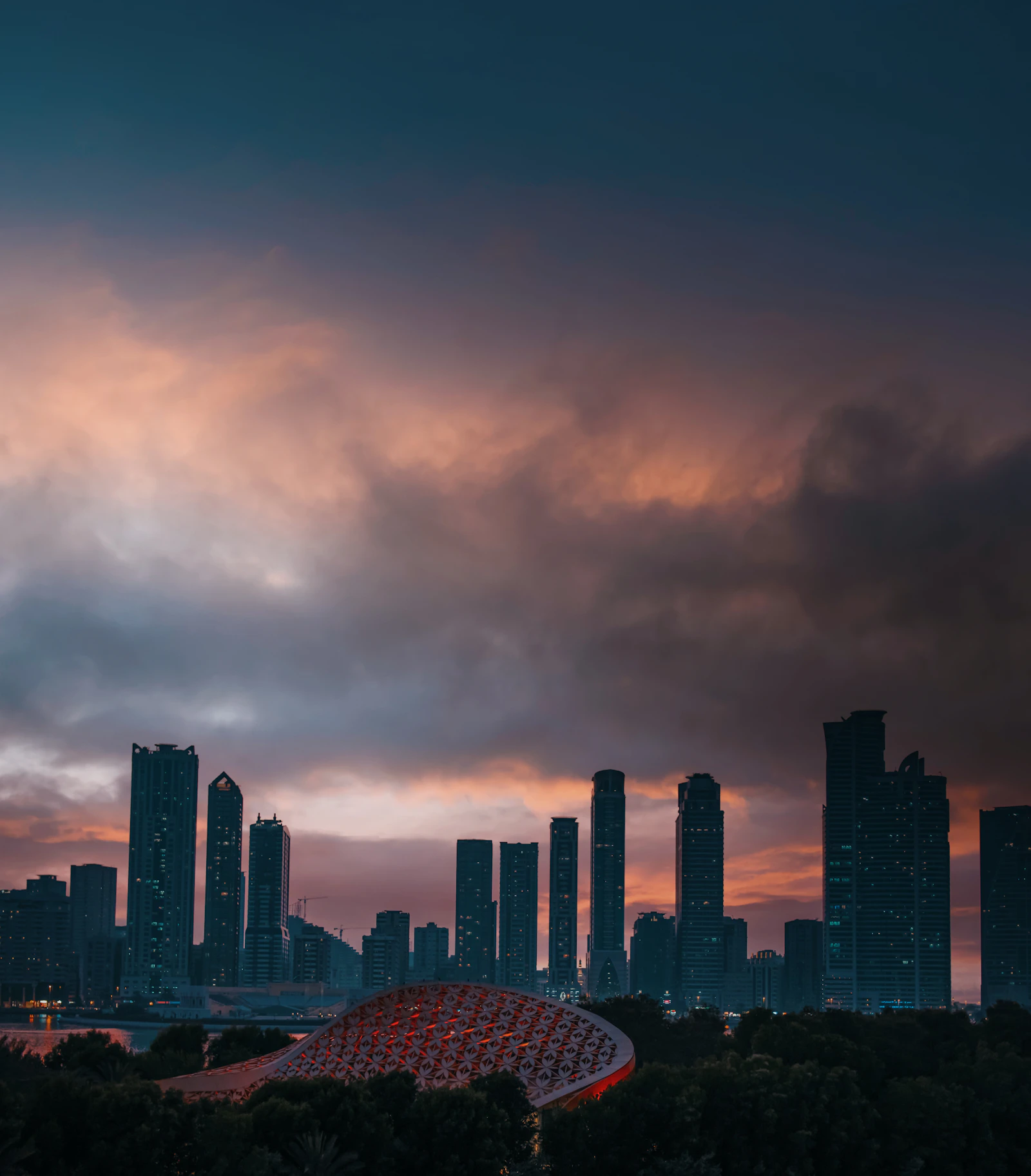 City towers across the skyline at dusk, seen from a distance