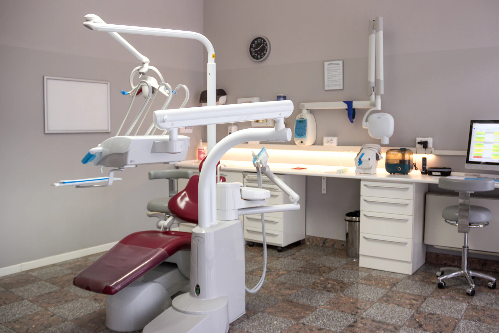 Clinic treatment room with an examination chair, equipment and a desk